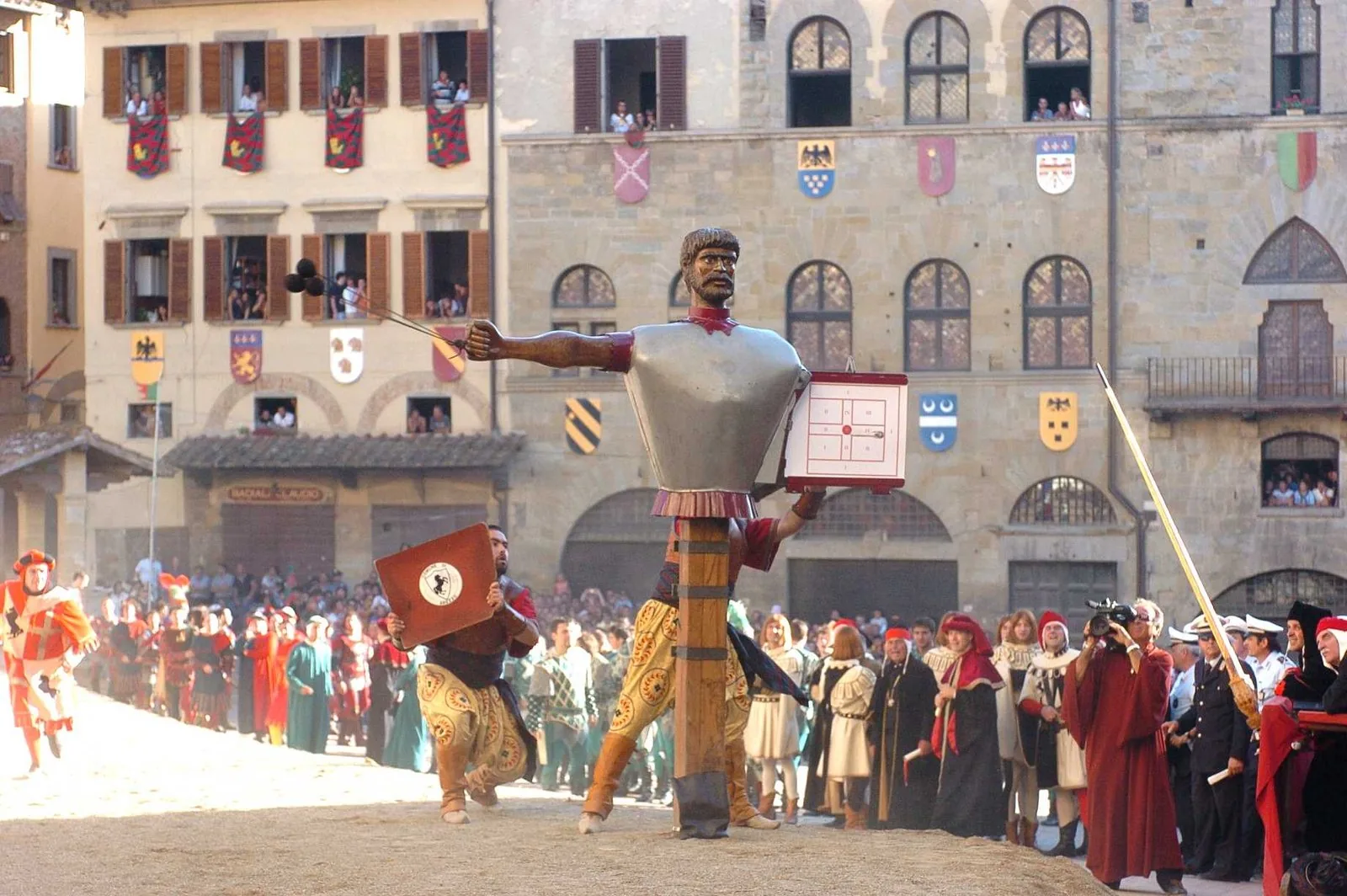 Il Buratto della Giostra del Saracino in Piazza Grande ad Arezzo, con figuranti in costume e il pubblico alle finestre