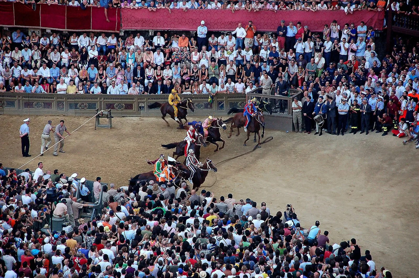 I cavalli del Palio di Siena alla partenza in Piazza del Campo, circondati dalla folla
